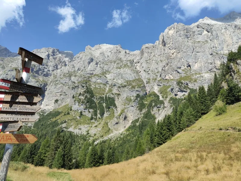 Segnavia in legno vicino al Rifugio Scarpa con le indicazioni per il Monte Agner, la via ferrata e i sentieri verso Taibon Agordino