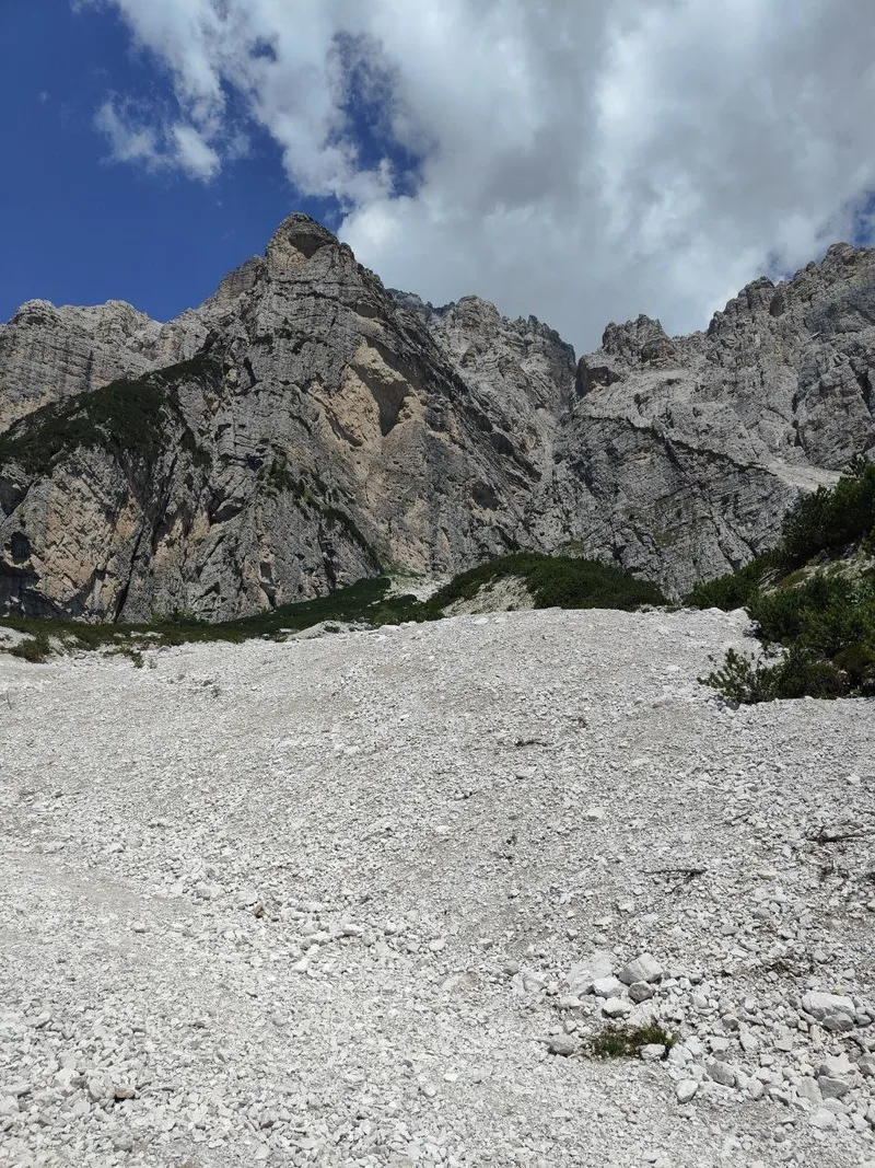 Ghiaione bianco ai piedi delle pareti rocciose sul sentiero per il Rifugio Carestiato, paesaggio quasi lunare